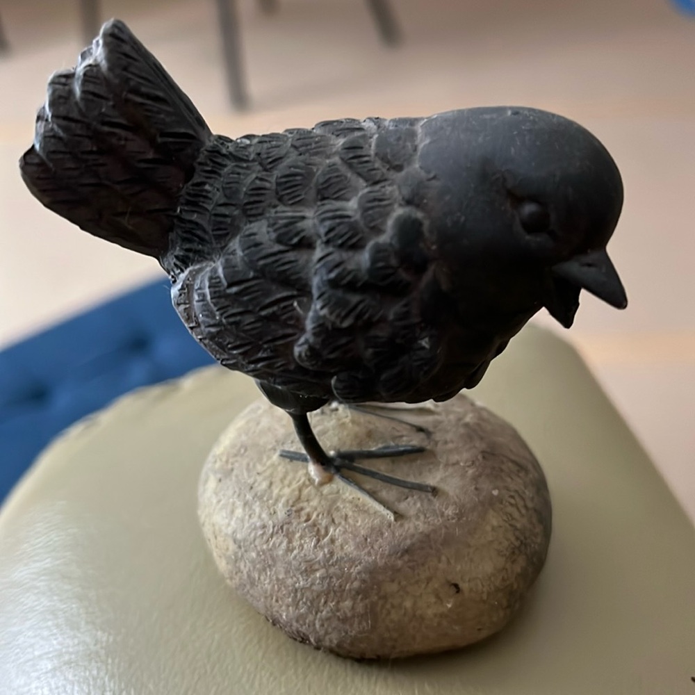 Sweet decoration next to a plant . This little bird is adorable